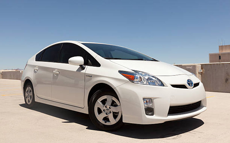 Scottsdale, United States - July 13, 2011: A photo of a parked white Toyota Prius sedan. The prius is a hybrid car, that runs on half gas and half electricity from batteries.